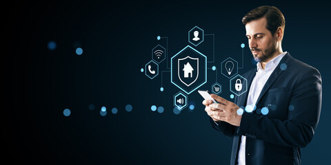 Businessman using smartphone to control smart home IoT system with glowing icons and digital interface on abstract dark background.