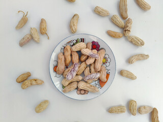 Top view of Boiled peanuts served on a plate against. peanuts on a white background.
