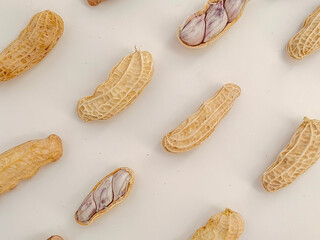 Close up, top view of peanuts against a white background as a pattern.
