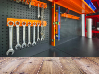Wooden table top over blurry background of power tools on shelf display background.