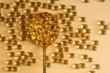 Capsules of vitamin D3 on a yellow background with free space. Biologically active substances of the calciferol group are fat-soluble organic compounds.