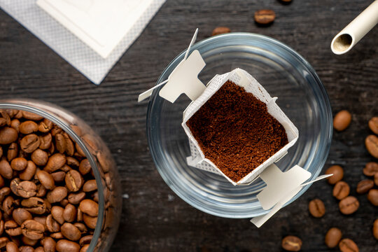 Drip bag in a glass with coffee beans. Drip coffee using a paper type filter.