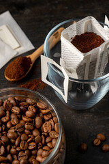 Drip bag in a glass with coffee beans. Drip coffee using a paper type filter.