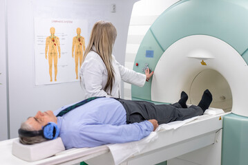 Doctor operates MRI machine with patient lying down for medical scan