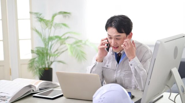 現場事務所で電話対応する作業員　発注や下請けで納期に困る　スマホでクレームの応対の動画
