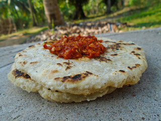 Delicious flatbread with spicy chili paste served outdoors in natural light. Rustic food photography showcasing authentic street food