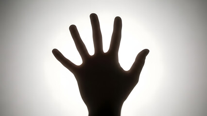 Conceptual Silhouette of a Human Hand Reaching Out Against a Strong White Light Source for Hope and Divinity