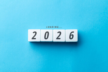 Loading 2026 concept with white blocks on a blue background. Minimalist flat lay representing the arrival of the new year, future planning, business goals, and transition to 2026.