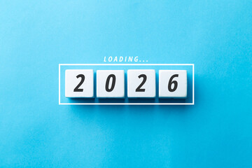Loading 2026 concept with white blocks on a blue background. Minimalist flat lay symbolizing future planning, business goals, and the arrival of the new year with progress and change.