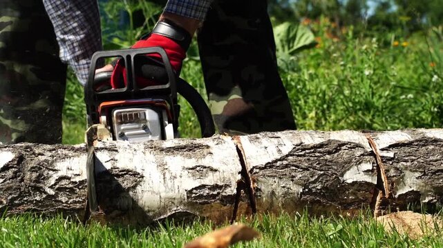 A man cuts wood with a chainsaw