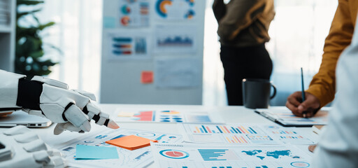 A futuristic robot hand interacts with data and charts in a modern business meeting, showcasing...