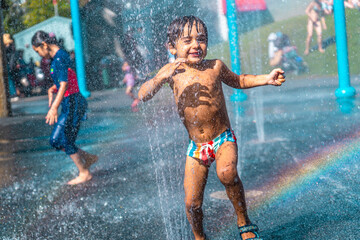 Happy child playing in a water fountain in vancouver, british columbia