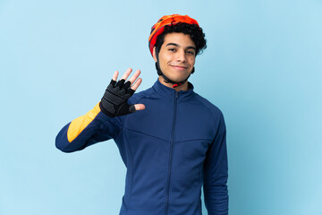 Venezuelan cyclist man isolated on blue background counting five with fingers