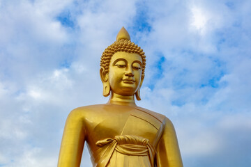 Obraz premium Giant golden Buddha statue at Wat Paknam, Bangkok, Thailand. Cloudy blue sky in the background. Measuring 69 meters tall (226 feet, it is the largest Buddha statue in Bangkok. 