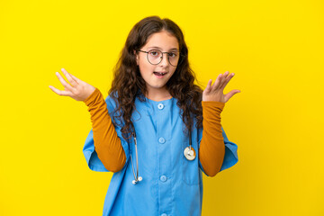 Little nurse girl isolated on yellow background with shocked facial expression