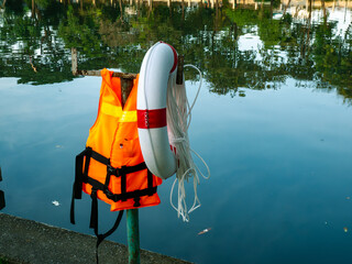 Life Jacket and Buoy: Orange Safety Vest Floating Device Water Rescue Equipment Pool Reflection Background