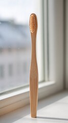 Eco friendly bamboo toothbrush standing on a windowsill with natural light