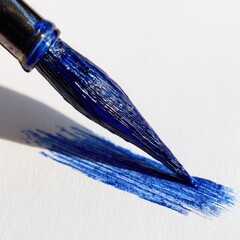 Close up of a blue ink pen creating brush strokes on white paper