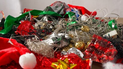 Christmas wrapping paper waste. Broken Christmas tree lights, old decorations, holiday cards, tin foil, festive plastic packaging, ribbons