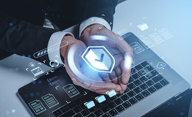 Businessman hands shielding digital security checkmark hologram above a laptop keyboard on futuristic background, representing data protection concept.