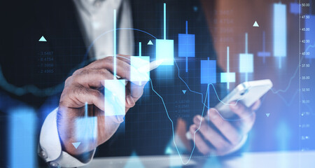 Businessman analyzing forex chart with smartphone and stylus on futuristic screen representing market trends, investment, and digital exchange concept.