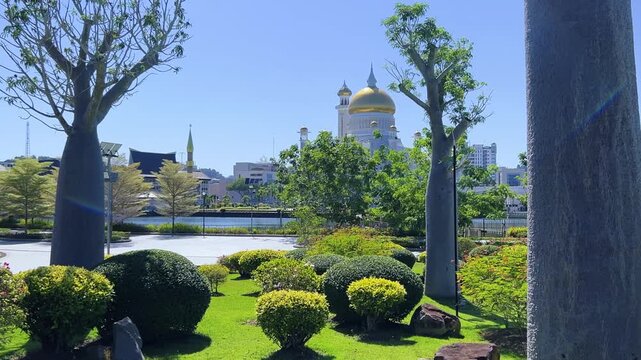 Brunei Darussalam - June 25, 2025: Sultan Omar Ali Saifuddin Mosque in Bandar Seri Begawan. Mosque with baobab trees in the foreground. Mosque facade and dome in sunlight. 4К