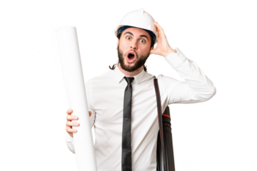 Young architect man with helmet and holding blueprints over isolated chroma key background with surprise expression
