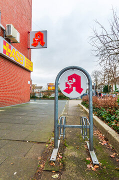 ISERLOHN, GERMANY &mdash; DECEMBER 12, 2025: A red German pharmacy sign (Apotheke) and ASB office building in the Letmathe district.