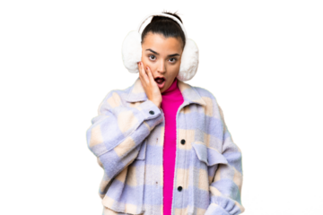 Young woman wearing winter muffs over isolated chroma key background surprised and shocked while looking right