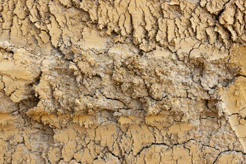 Fototapeta premium Close up of cracked yellow dry clay surface texture background