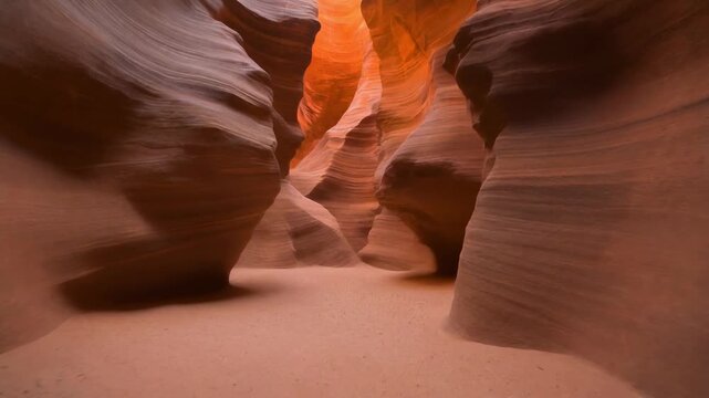Immersive view inside a majestic slot canyon with warm sunlight highlighting the sculpted sandstone walls, revealing ancient geological formations and natural beauty.