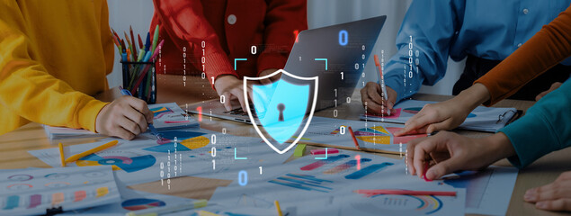 A vibrant office scene showcasing team collaboration on digital security concepts, featuring a shield graphic overlay blending innovation with teamwork and creativity. Trope