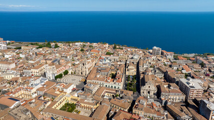 Naklejka premium Aerial view of the historic center of Acireale, in the province of Catania, Sicily, Italy. The cathedral is in the center. It is a beautiful Sicilian town. On the horizon, is the Mediterranean sea.