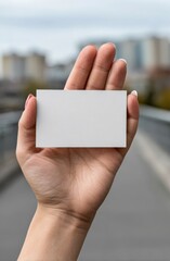 A woman's hand holds a clean, blank white business card, offering a minimalist mockup for designers.