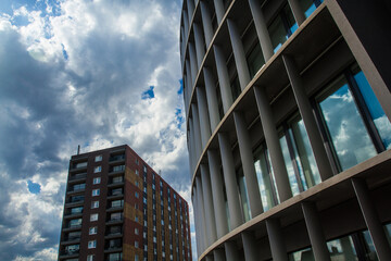 Urban architecture with residential brick tower, glass and concrete office building.
