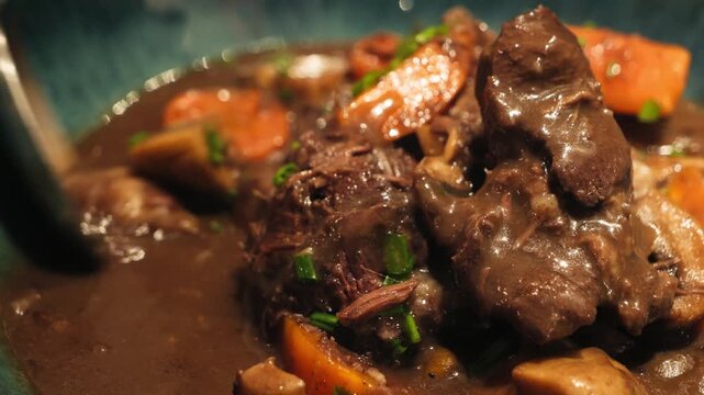 Beef Bourguignon is a classic French dish of beef braised in a rich sauce of red wine, vegetables, and mushrooms, incredibly tender beef. High quality 4k footage
