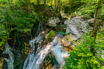 Majestic Sunik Waterfalls cascading through lush Triglav National Parks emerald Soca Valley