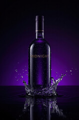 Dark purple liquor bottle splashing water in dramatic studio lighting