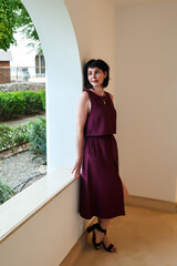 woman in an evening dress near an arch in a house.