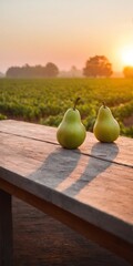 Pear fruits on wooden table, field garden in background.
