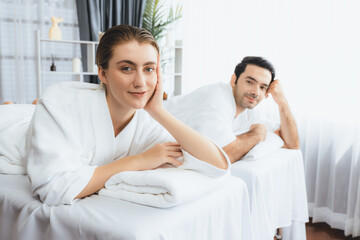 Obraz premium Caucasian couple customer enjoying relaxing anti-stress spa massage and pampering with beauty skin recreation leisure in day light ambient salon spa at luxury resort or hotel. Quiescent