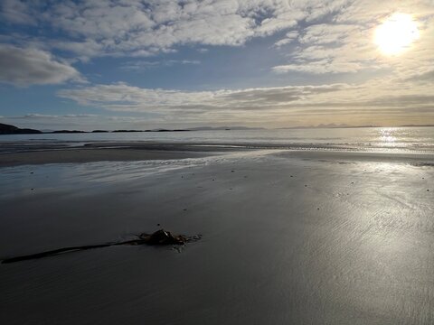 Beautiful wild beach Isle of Mull Scotland Uisken the beautiful rocky and sandy shore sunrise with water pools reflect sun light  vast ocean on horizon with wildlife  and blue sky in Winter no people
