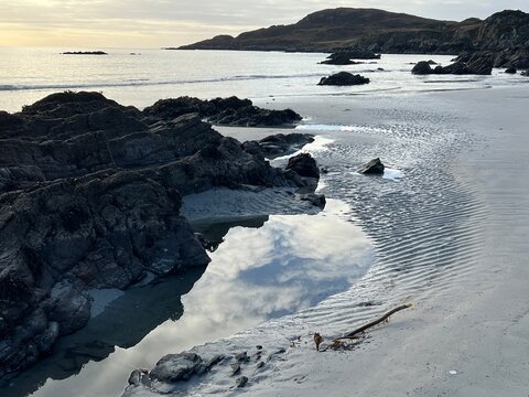 Beautiful wild beach Isle of Mull Scotland Uisken the beautiful rocky and sandy shore sunrise with water pools reflect sun light  vast ocean on horizon with wildlife  and blue sky in Winter no people