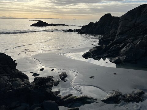 Beautiful wild beach Isle of Mull Scotland Uisken the beautiful rocky and sandy shore sunrise with water pools reflect sun light  vast ocean on horizon with wildlife  and blue sky in Winter no people