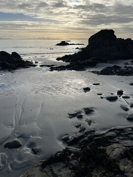 Beautiful wild beach Isle of Mull Scotland Uisken the beautiful rocky and sandy shore sunrise with water pools reflect sun light  vast ocean on horizon with wildlife  and blue sky in Winter no people