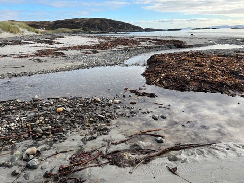 Beautiful wild beach Isle of Mull Scotland Uisken the beautiful rocky and sandy shore sunrise with water pools reflect sun light  vast ocean on horizon with wildlife  and blue sky in Winter no people