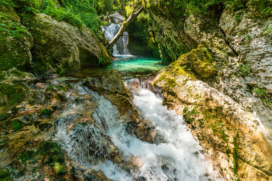 Majestic Sunik Waterfalls cascading through lush Triglav National Parks emerald Soca Valley