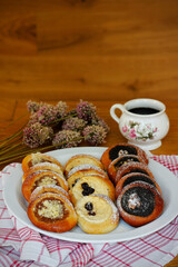 Traditional Czech festive kolache with apple, curd cheese and poppy seed filling served on plate with coffee cup and dried allium bouquet, vertical image with copy space