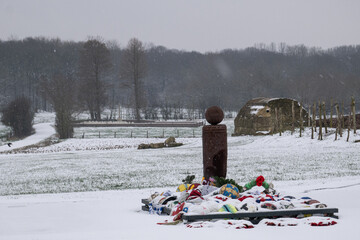 Christmas Truce Memorial 1914 in Ploegsteert Belgium during winter snowfall. World war one commemorative monument with footballs and wreaths in the snow.