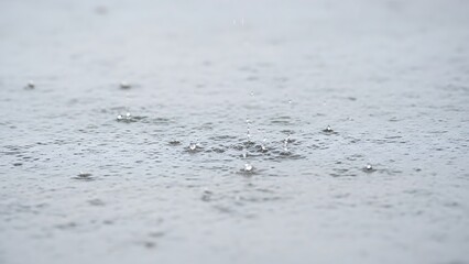 Abstract close-up of fine metallic particles and dust scattered across a textured light grey surface, highlighting granular details and material properties